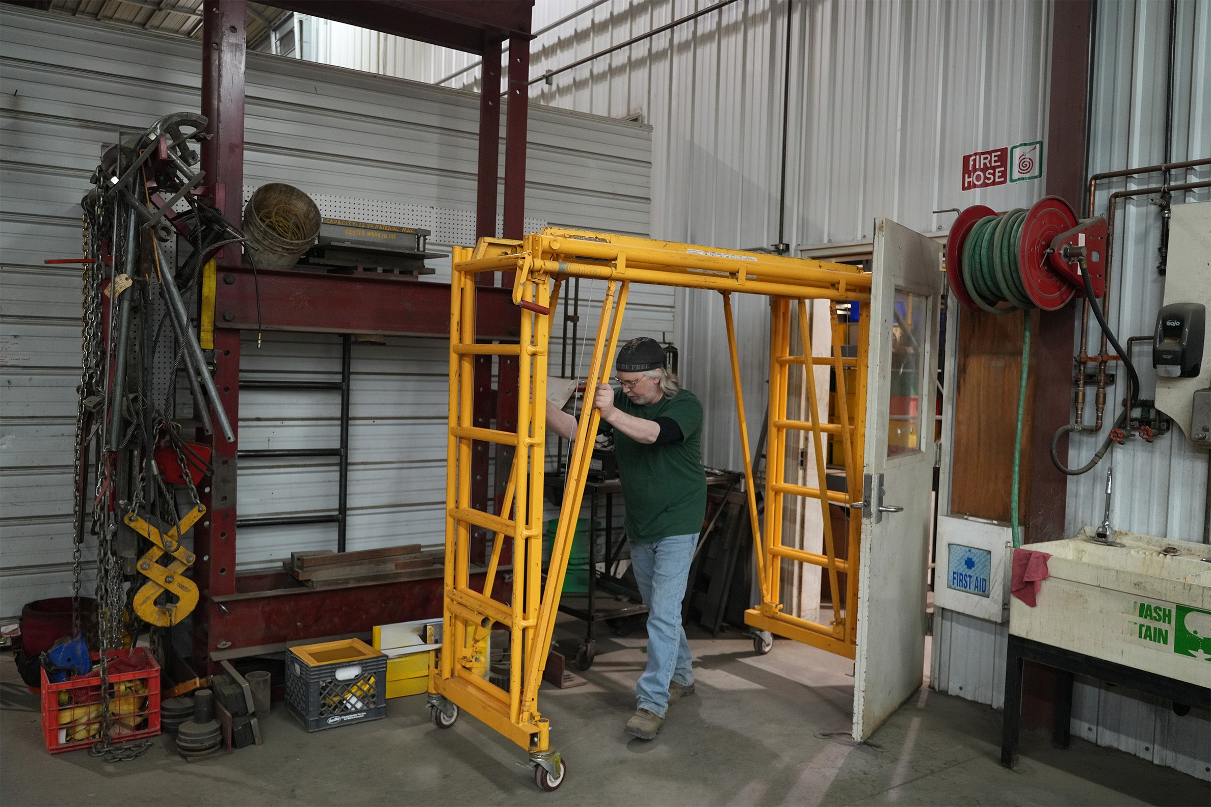Person working with a yellow industrial lift in a warehouse setting